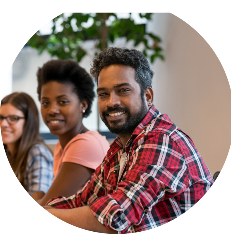 Workers at conference table smiling.